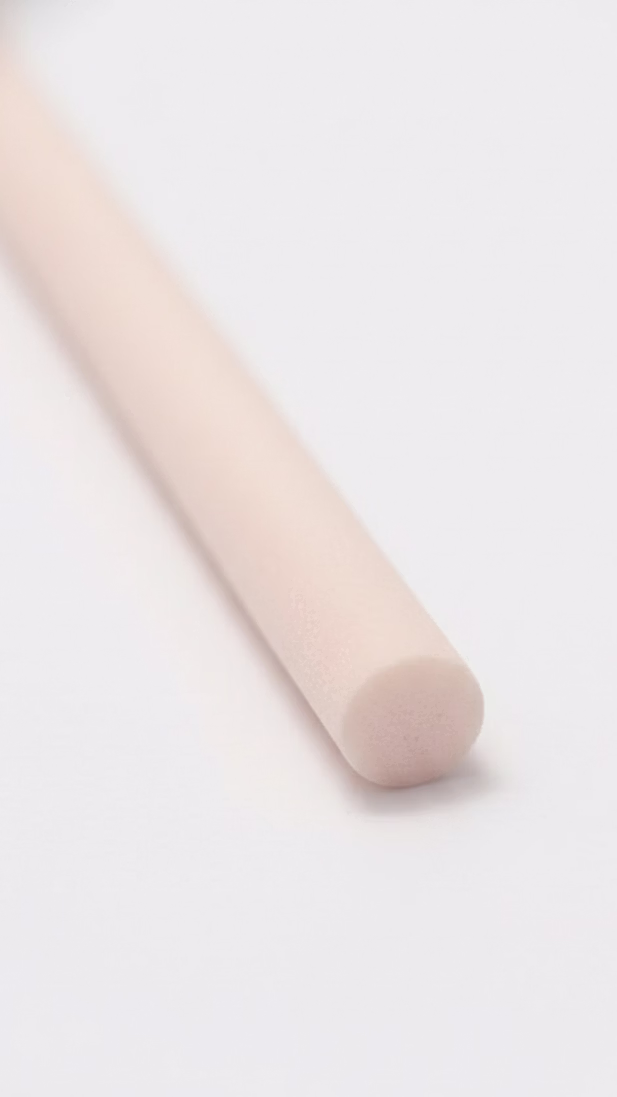 Single beige fibre diffuser reed stick on a clean white surface.