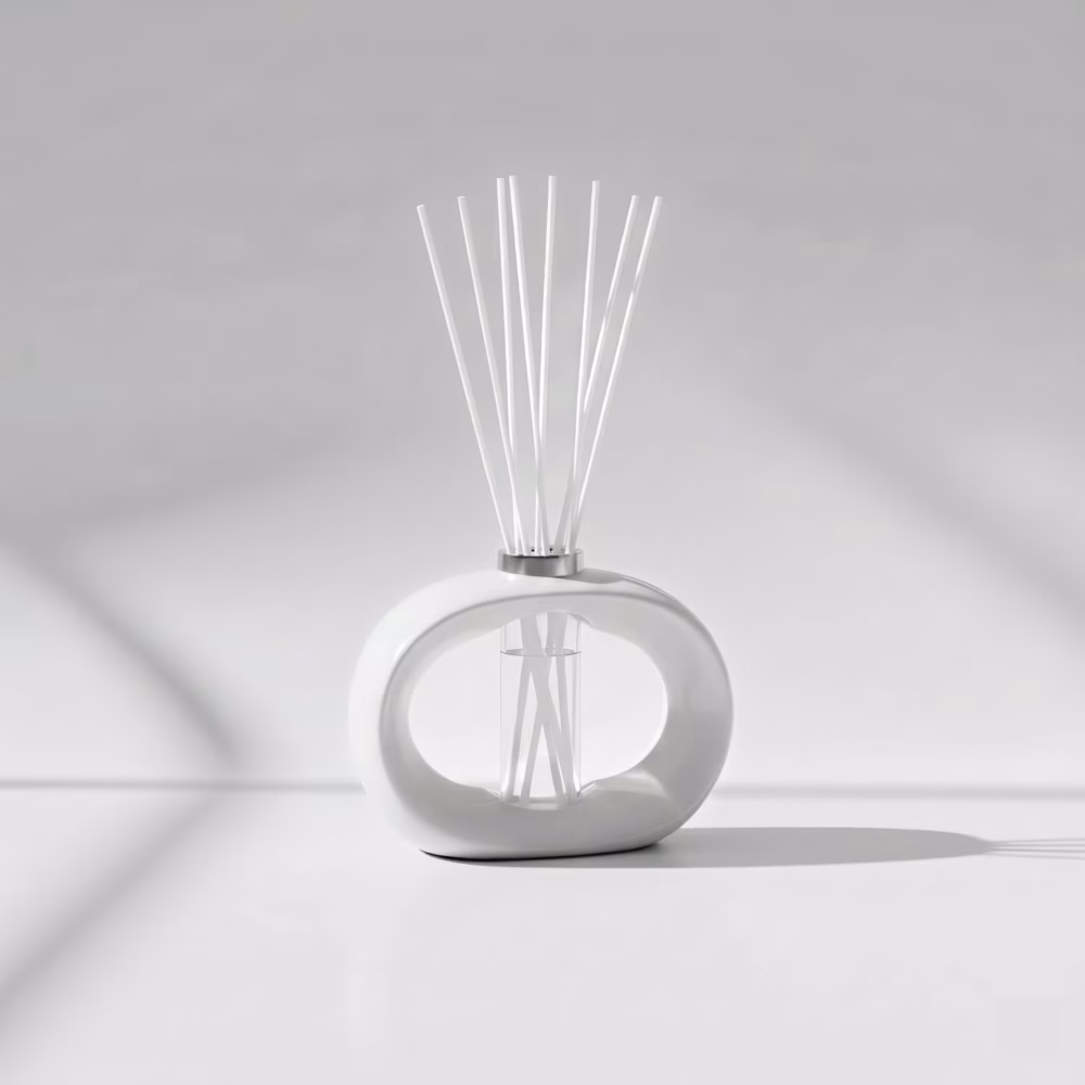 White porcelain reed diffuser with white reeds on a clean, minimalist surface