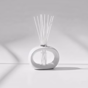 White porcelain reed diffuser with white reeds on a clean, minimalist surface