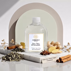 Amberly Zen Tea & Ginger diffuser refill styled with white tea leaves, fresh ginger, cinnamon sticks and star anise on marble.